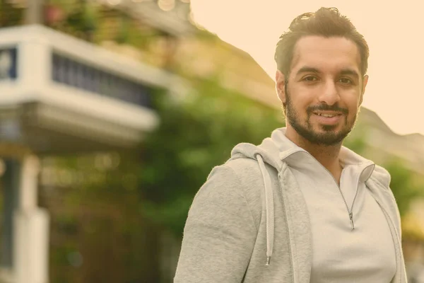 Glücklicher junger gutaussehender bärtiger indischer Mann, der draußen lächelt — Stockfoto