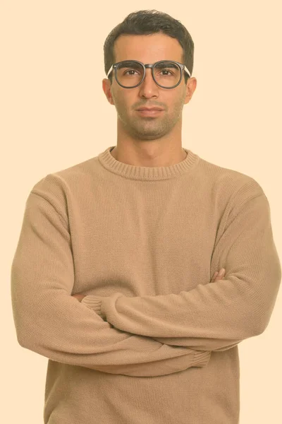 Portrét mladého pohledného íránského muže v brýlích se zkříženýma rukama — Stock fotografie