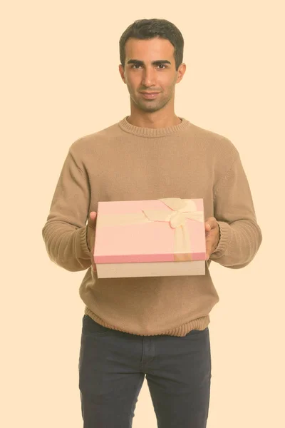 Молодой красивый иранский мужчина с подарочной коробкой на день святого Валентина — стоковое фото