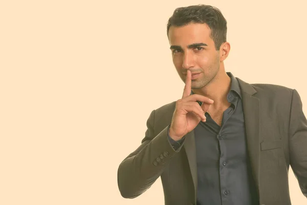 Fiatal jóképű iráni üzletember ujjal az ajkain — Stock Fotó