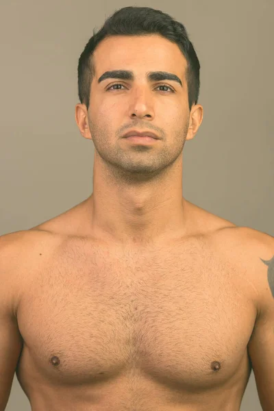 Face of young handsome Iranian man shirtless