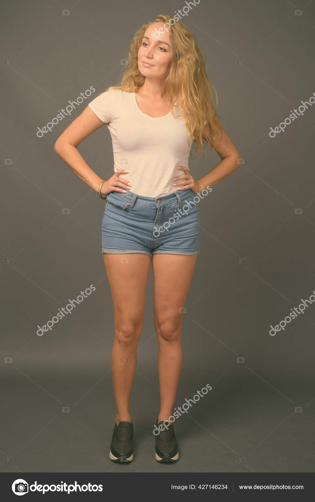 Full body shot of happy young beautiful blonde woman Stock Photo