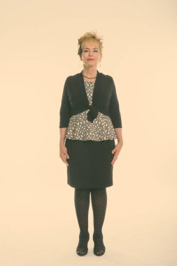 Beyaz arka planda kısa saçlı, yakışıklı Asyalı iş kadınının stüdyo fotoğrafı.