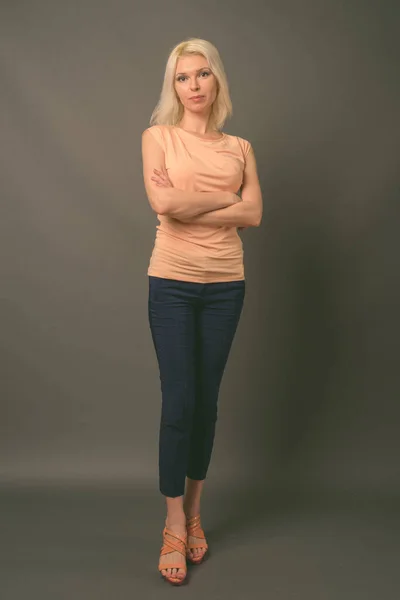 Schöne Frau mit blonden Haaren vor grauem Hintergrund — Stockfoto