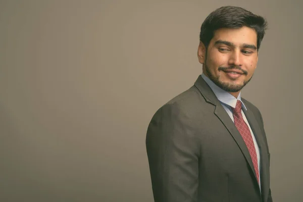 Studioaufnahme Eines Jungen Gutaussehenden Bärtigen Persischen Geschäftsmannes Vor Grauem Hintergrund — Stockfoto