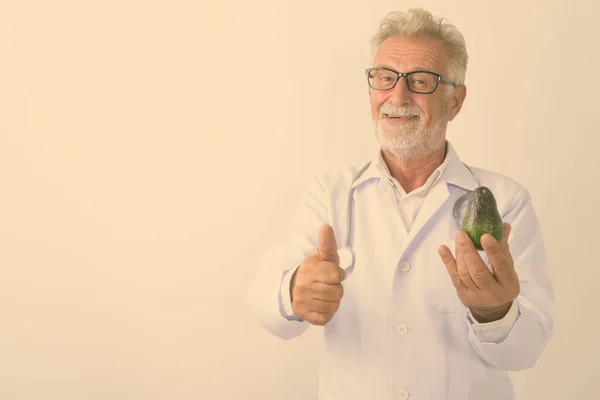 Studio Colpo Felice Anziano Barbuto Uomo Medico Sorridente Tenendo Avocado — Foto Stock