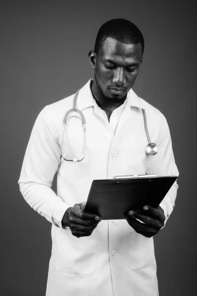 スタジオショットのハンサムなアフリカ人男性医師に対して茶色の背景 — ストック写真