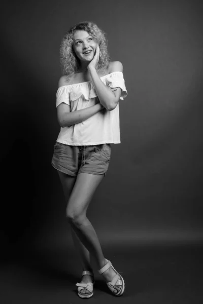 电影制片厂拍摄的年轻美丽女子 金发卷曲 背景灰白 — 图库照片