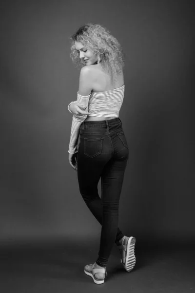 电影制片厂拍摄的年轻美丽女子 金发卷曲 背景灰白 — 图库照片