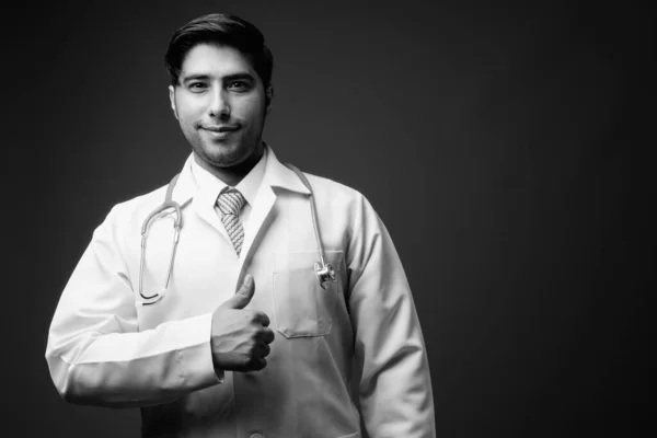 Studio Záběr Mladého Pohledného Íránského Muže Lékaře Hnědém Pozadí — Stock fotografie