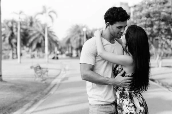 Jovem casal hispânico relaxando no parque juntos — Fotografia de Stock