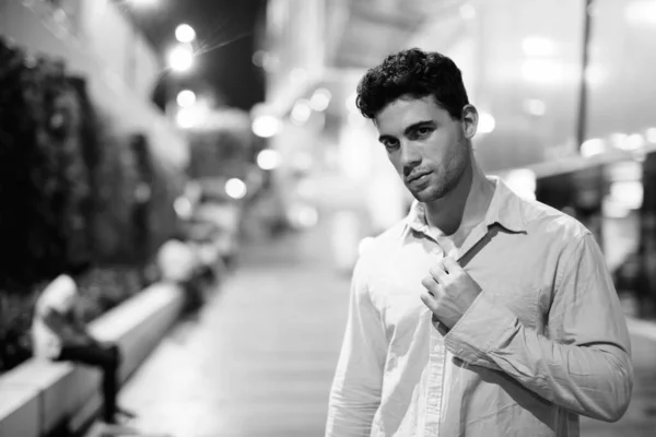 Young handsome Hispanic man exploring the city streets at night — Stock Photo, Image