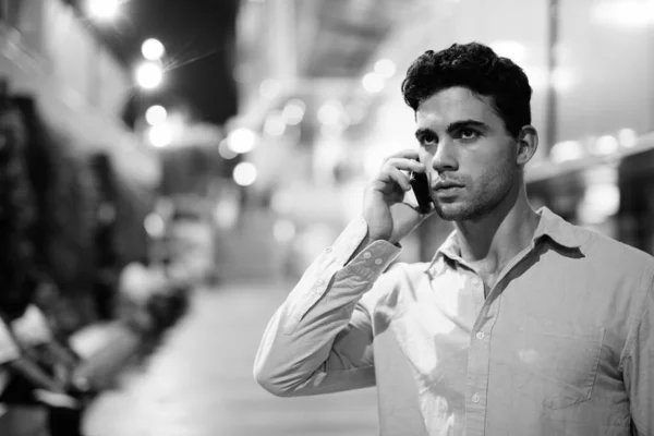 Joven hombre hispano guapo explorando las calles de la ciudad por la noche — Foto de Stock