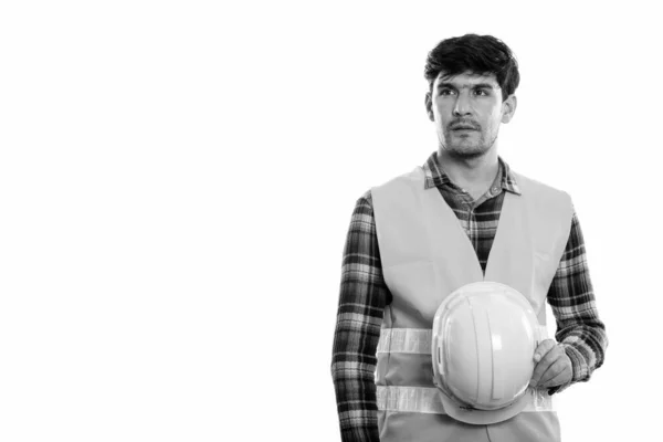 Young Persian man construction worker holding safety helmet while thinking — Stock Photo, Image