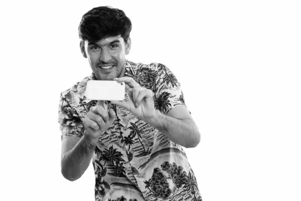 Studio girato di giovane felice uomo persiano sorridente mentre scattava foto con il telefono cellulare — Foto Stock