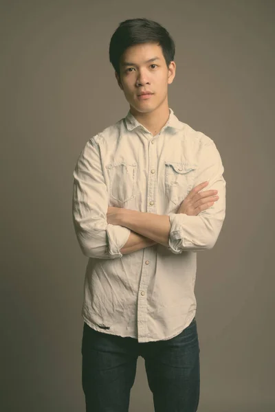 백발의 뒷배경에 흰 셔츠를 입고 있는 젊고 잘생긴 아시아 사업가 — 스톡 사진