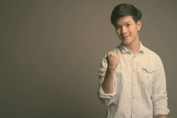 Jovem bonito empresário asiático vestindo camisa branca contra fundo cinza — Fotografia de Stock