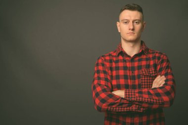 Genç ve yakışıklı adamın gri arka planda çekimleri.