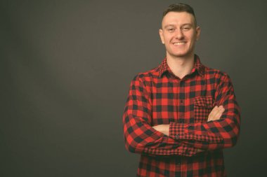 Genç ve yakışıklı adamın gri arka planda çekimleri.