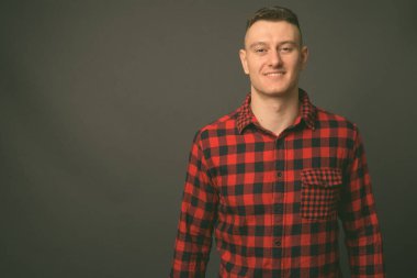 Genç ve yakışıklı adamın gri arka planda çekimleri.