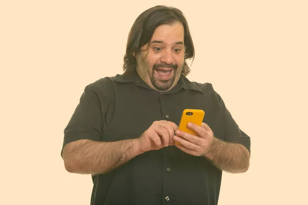 Glücklicher dicker Mann aus dem Kaukasus lacht, während er sein Handy benutzt — Stockfoto