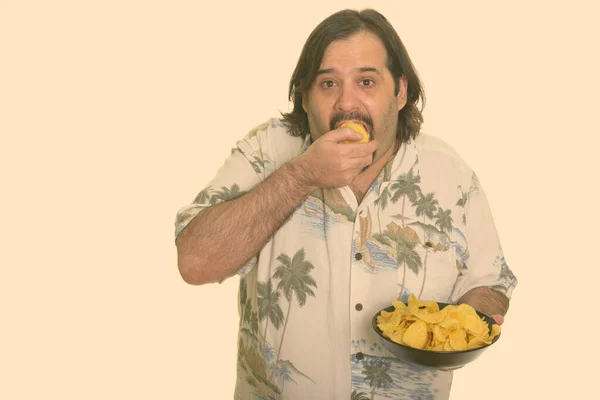 Fat Caucasian man eating mouthful of chips ready for vacation — Stock Photo, Image