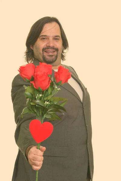 Feliz gordo caucásico hombre de negocios sonriendo dando rosas rojas y el corazón listo para el día de San Valentín —  Fotos de Stock