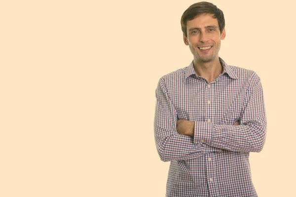 Estudio de disparo de joven empresario feliz sonriendo con los brazos cruzados — Foto de Stock