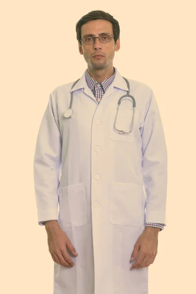 Студійний знімок молодого красивого лікаря, що стоїть під час носіння окулярів — стокове фото