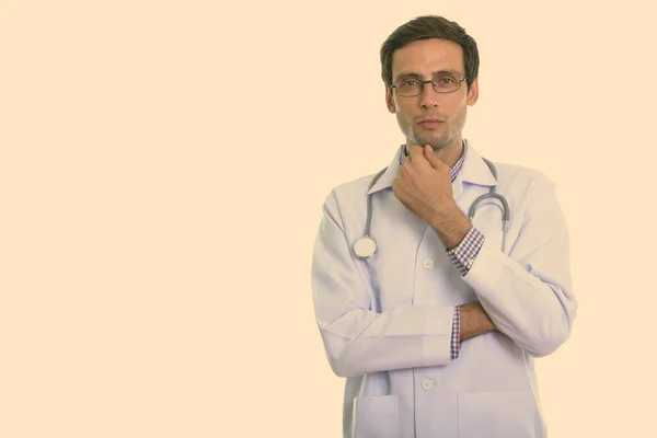 Estúdio tiro de homem bonito jovem médico pensando — Fotografia de Stock