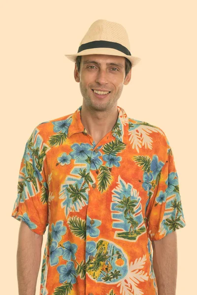 Studio shot of young happy tourist man smiling ready for vacation — Stock Photo, Image