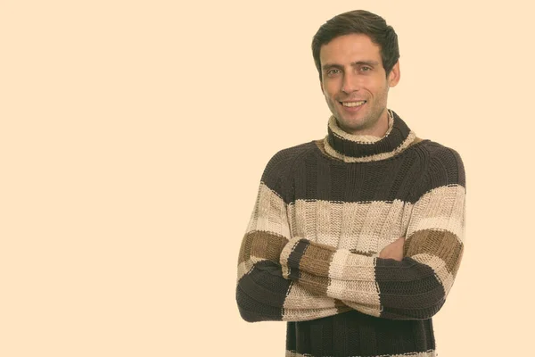 Estudio de tiro de hombre joven y guapo feliz sonriendo con los brazos cruzados — Foto de Stock