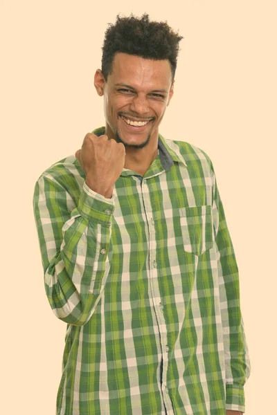 Студийный снимок молодого счастливого африканца, улыбающегося, выглядящего мотивированным — стоковое фото