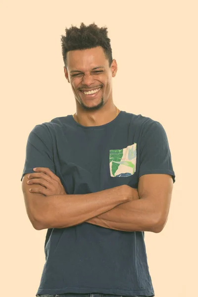 Estudio disparo de joven feliz africano sonriendo con los brazos cruzados y los ojos cerrados —  Fotos de Stock