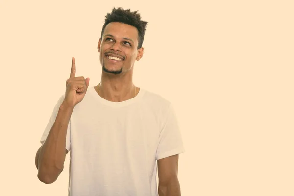 Pensativo jovem feliz Africano homem sorrindo enquanto apontando dedo para cima — Fotografia de Stock