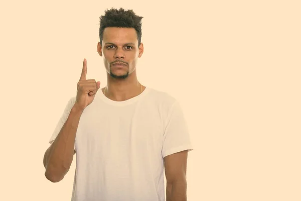 Estudio de un joven africano apuntando con el dedo hacia arriba — Foto de Stock