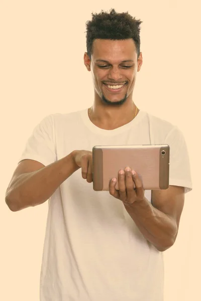 Estúdio tiro de jovem feliz homem africano sorrindo ao usar tablet digital — Fotografia de Stock