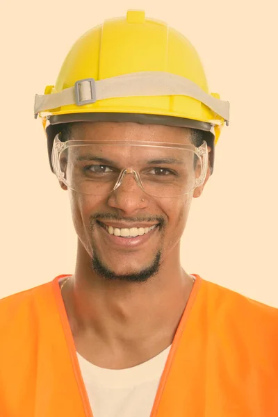 Gezicht van gelukkig Afrikaans man bouwvakker glimlachen terwijl het dragen van beschermende bril — Stockfoto