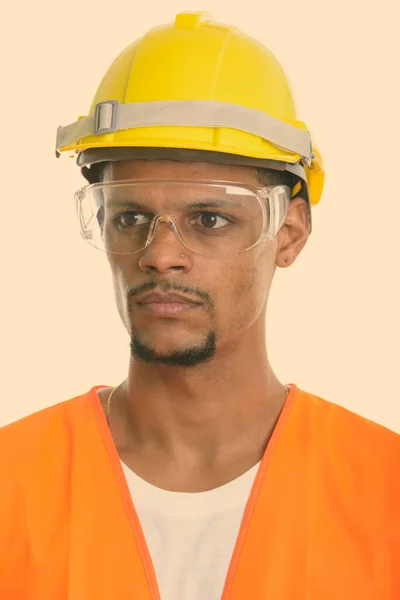 保護眼鏡をかけながら考える若いアフリカ人建設労働者の顔 — ストック写真