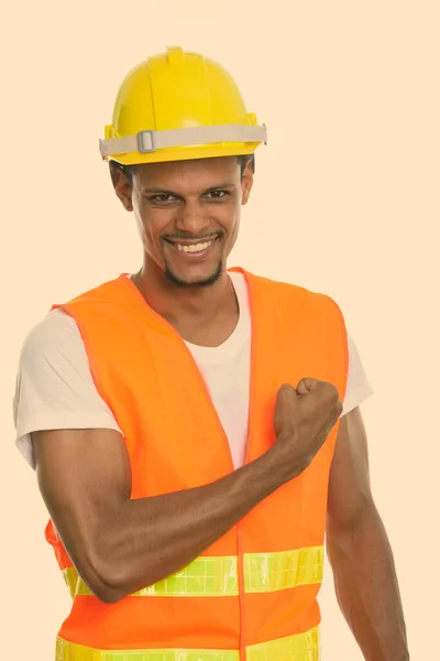 Młody szczęśliwy Afrykanin budowlany pracownik uśmiecha się z ręką na piersi — Zdjęcie stockowe