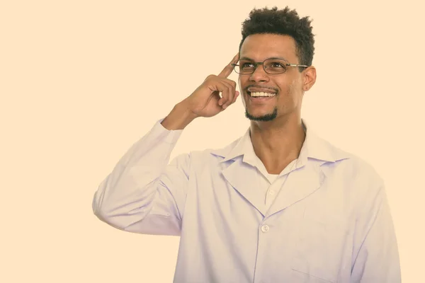 Ung glad afrikansk man läkare ler samtidigt tänka med fingret på huvudet — Stockfoto