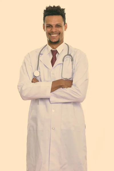 Young happy African man doctor smiling and standing with arms crossed — Stock Photo, Image