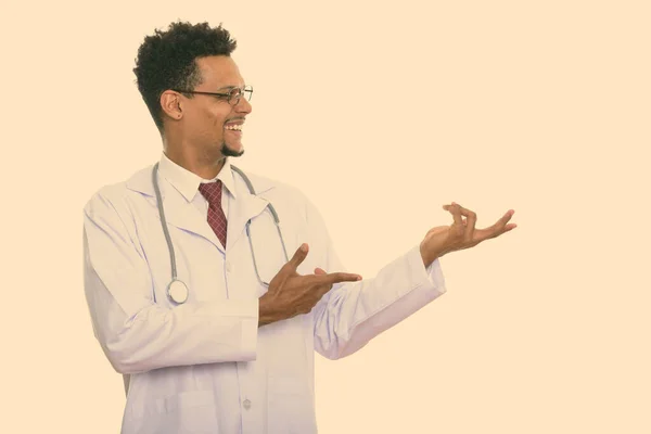 Profile view of happy African man doctor smiling while showing something — Stock Photo, Image