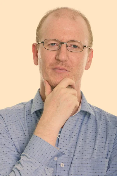 Студійний знімок бізнесмена, який думає під час носіння окулярів — стокове фото
