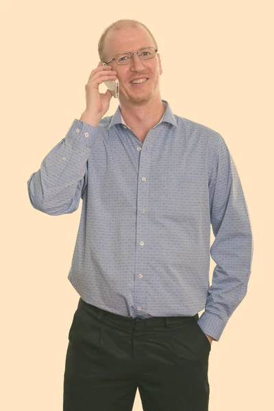 Studio skott av glad affärsman ler när du talar på mobiltelefon — Stockfoto