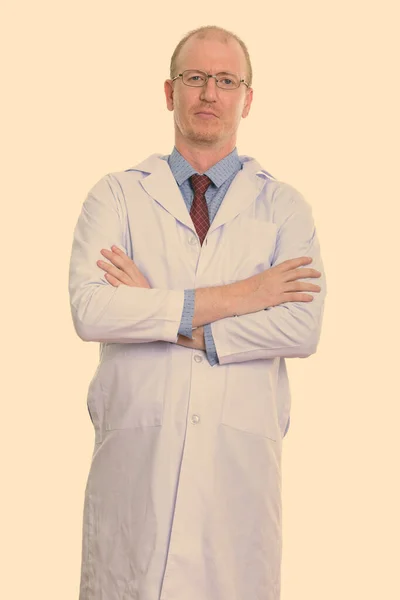 Studio záběr muže lékař stojící se zkříženýma rukama — Stock fotografie