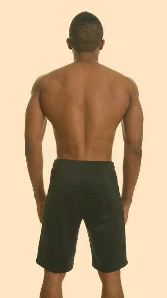 Vista posterior de un joven apuesto hombre africano sin camisa con músculos definidos —  Fotos de Stock