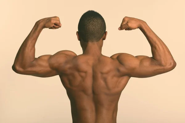 Joven musculoso africano hombre sin camisa flexión ambos brazos —  Fotos de Stock