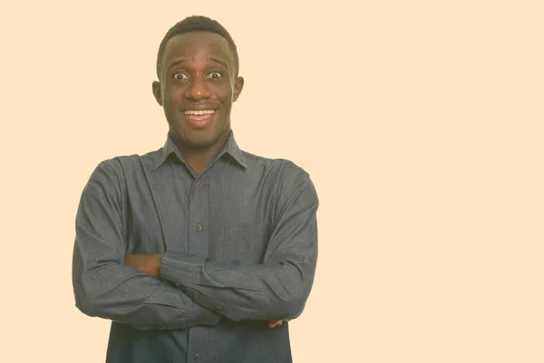 Genç mutlu Afrikalı adam gülümsüyor ve kolları bağlı heyecanlı görünüyor. — Stok fotoğraf