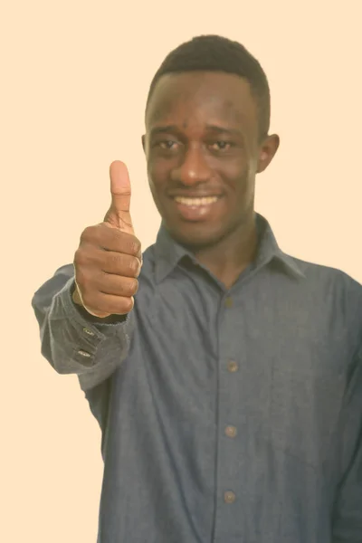 Genç mutlu Afrikalı adam gülümsüyor ve başparmağını başparmağına dikti. — Stok fotoğraf